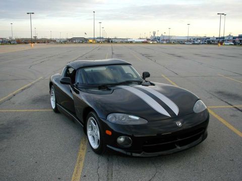 1996 Dodge Viper - A black 1996 Dodge Viper is parked in an empty lot under a cloudy sky.