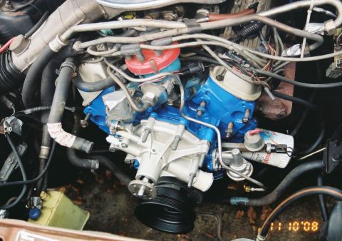 1980 Ford Mustang - Close-up view of an engine bay, blue valve covers and a prominent water pump.