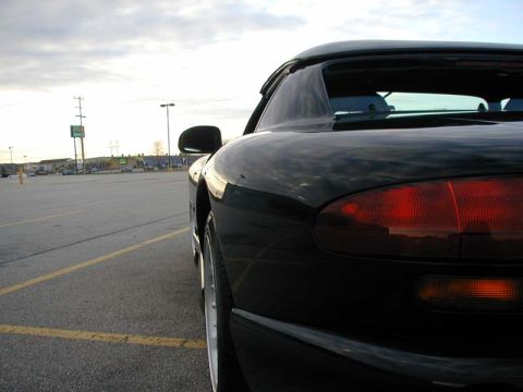1996 Dodge Viper - A black sports car is parked in a lot with a cloudy sky overhead. The rear of the vehicle is visible.