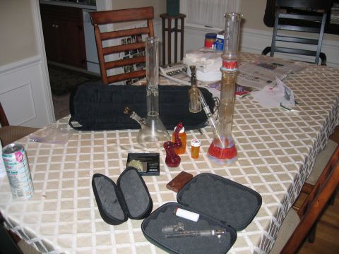 1996 Ford Crown Victoria - Drug paraphernalia including bongs, a scale, and smoking accessories are laid out on a table.