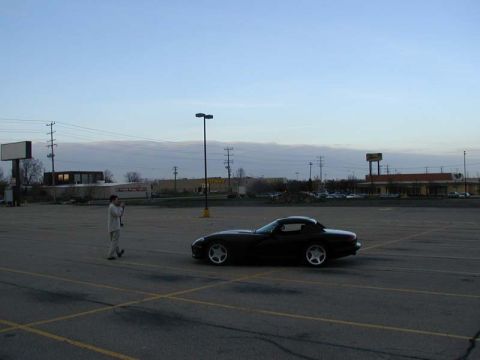 1996 Dodge Viper - A black 1996 Dodge Viper convertible is parked in an empty lot under a cloudy sky.