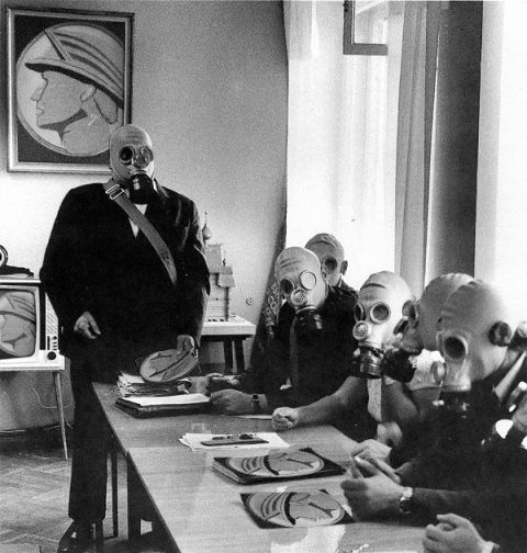 2003 Mercury Marauder - Several individuals in gas masks are gathered around a table, with one person standing and addressing the group.