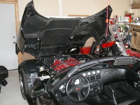 1996 Dodge Viper - The 1996 Dodge Viper's V10 engine is visible with the hood raised, revealing the car's interior and dashboard.