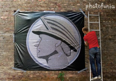 2003 Mercury Marauder - Man on ladder hangs a large banner with a profile image on a brick wall.