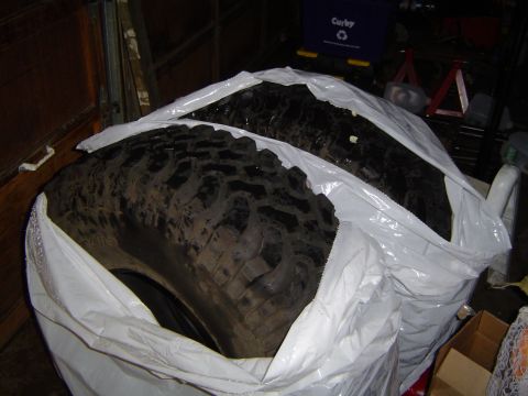 1989 Ford Bronco - Two tires are covered in plastic bags, likely for storage.