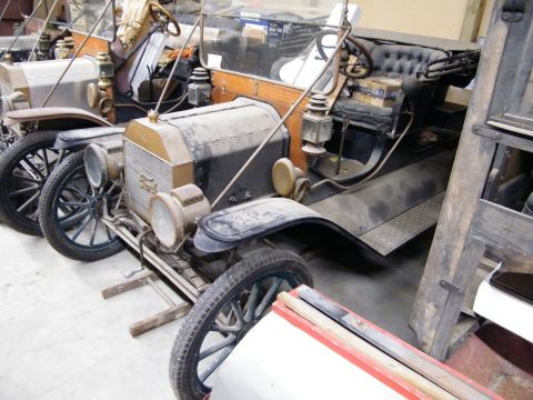 1909 Ford Model T - Two vintage Ford Model T cars are parked indoors, one in the foreground.