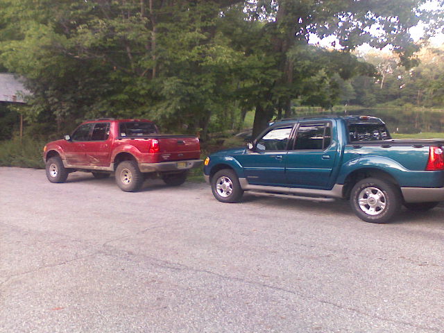 Teal 2001 Ford Explorer Sport Trac parked next to a red Ford Explorer Sport Trac