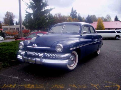 1969 Lincoln Continental - This 1950 Mercury Eight is parked next to a white limousine and a red car.