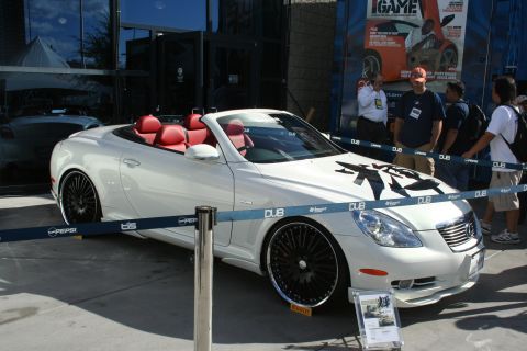 1998 Ford Crown Victoria - A white convertible sports car with a red interior and custom graphics on the hood is displayed outdoors.