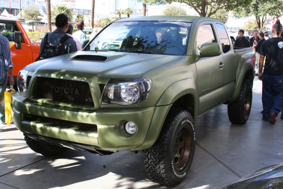 Matte green Toyota Tacoma pickup truck with off-road tires