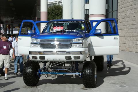 1998 Ford Crown Victoria - Customized pickup truck on display with its hood open, revealing engine modifications.