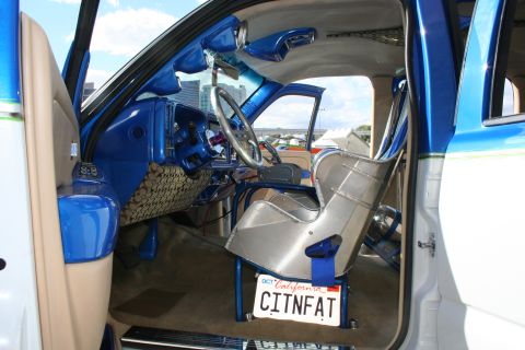 1998 Ford Crown Victoria - The interior of a heavily modified vehicle features a racing seat and custom blue dashboard.