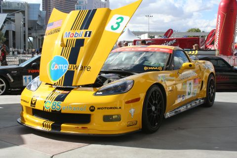 1998 Ford Crown Victoria - Yellow race car with hood open, displaying sponsor decals and racing numbers.