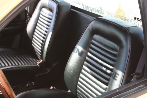 1998 Ford Crown Victoria - The interior of a vehicle shows black ribbed seats with sunlight casting shadows.