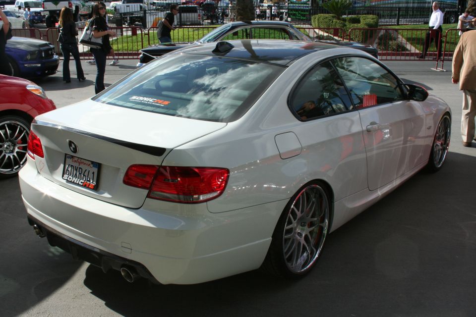 White coupe, rear view, custom wheels, California license plate