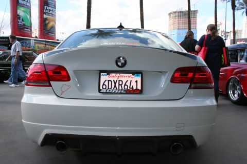 1998 Ford Crown Victoria - A white BMW 3 Series sedan is parked outdoors with a California license plate and a racing circuit sticker.