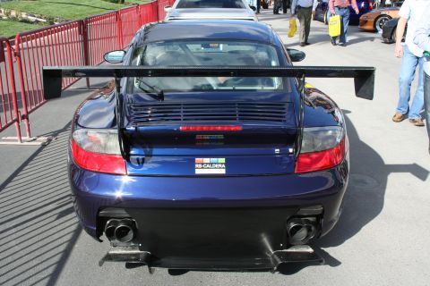1998 Ford Crown Victoria - Blue Porsche 911 GT3 RS with a prominent rear wing and dual exhaust pipes.