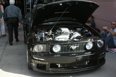 1998 Ford Crown Victoria - A black Ford Mustang is shown with its hood open, revealing the engine and aftermarket parts.