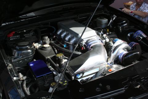 1998 Ford Crown Victoria - Close-up of a modified engine bay, showing custom intake and turbo components.
