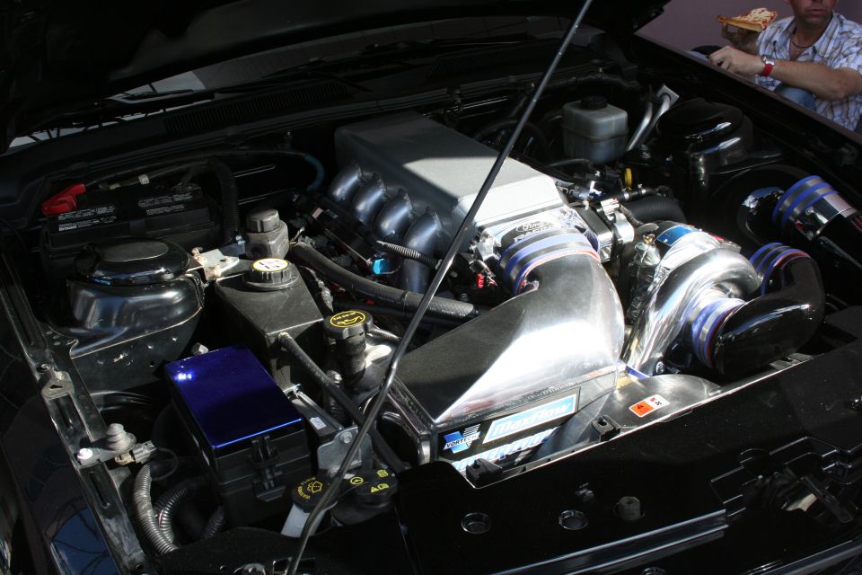 Engine bay with a large silver intake manifold and turbocharger. Blue accents on hoses