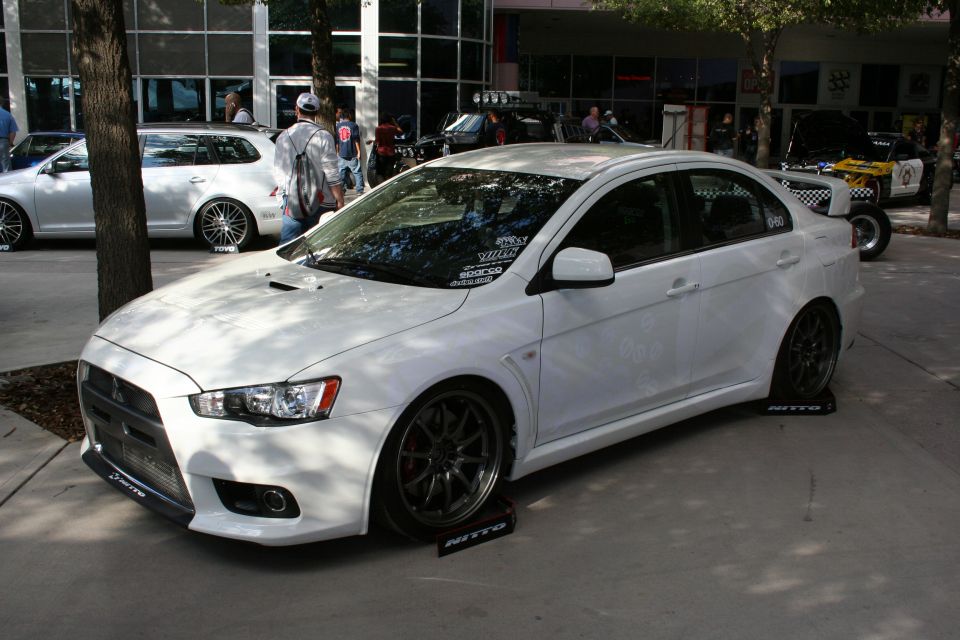 White Mitsubishi Lancer Evolution sedan with aftermarket wheels and body kit