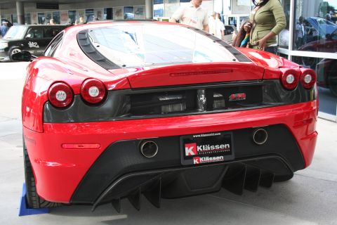 1998 Ford Crown Victoria - Rear view of a red Ferrari F430 sports car, showing its distinctive diffuser and exhaust system.