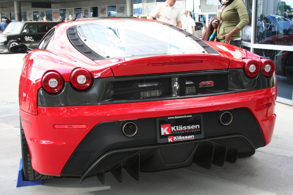Red Ferrari F430 rear view with quad exhaust and diffuser. License plate frame from Klassen