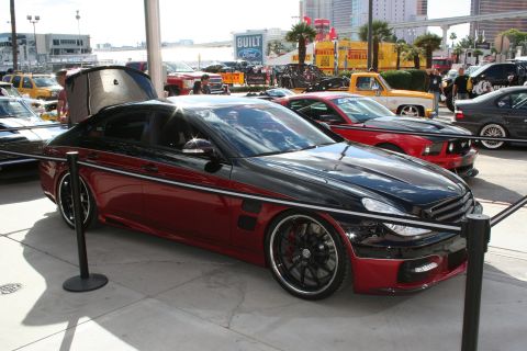 1998 Ford Crown Victoria - A customized sedan is displayed outdoors with other vehicles and buildings visible.
