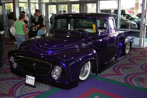 1998 Ford Crown Victoria - A custom purple pickup truck is displayed indoors with people in the background.