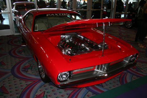 1998 Ford Crown Victoria - A red muscle car is displayed with its hood open, revealing a supercharged engine and Paxton branding on the windshield.