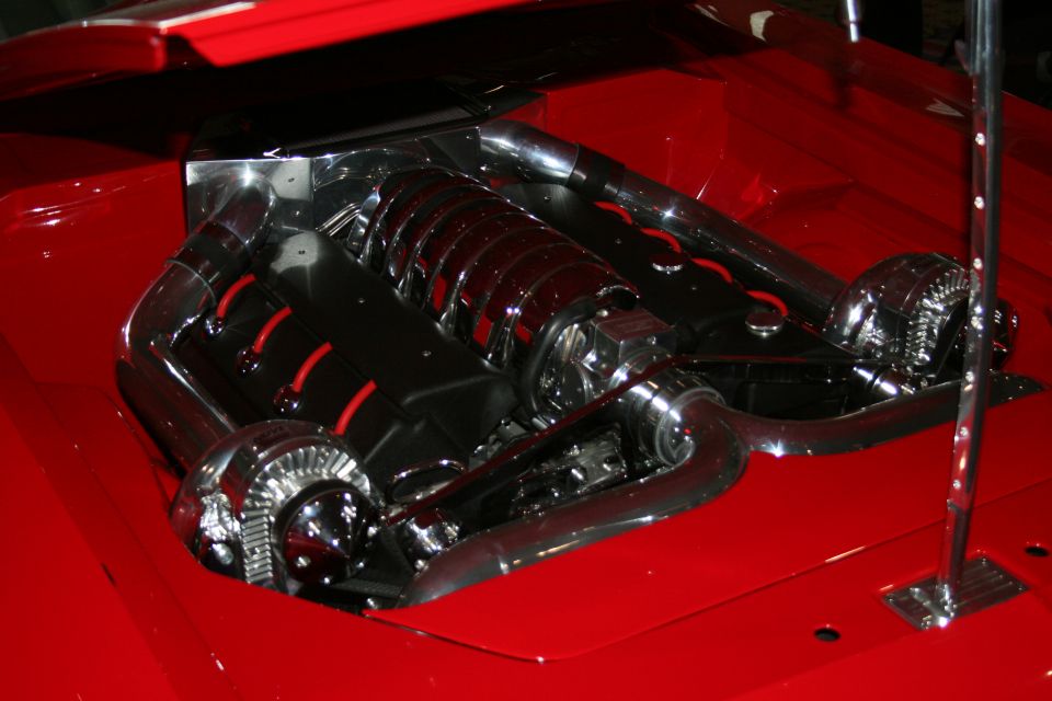 Customized V8 engine bay with polished chrome intake manifold, twin turbochargers, and red accents