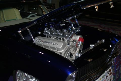 1998 Ford Crown Victoria - A custom Chevrolet V8 engine is visible under the open hood of a dark blue vehicle.