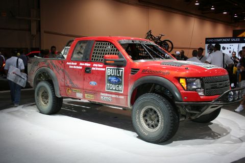 1998 Ford Crown Victoria - This modified Ford F-150 Raptor race truck is displayed indoors, likely at a show or event.