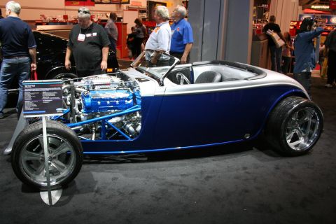 1998 Ford Crown Victoria - A custom hot rod with a powerful blue engine is displayed indoors.