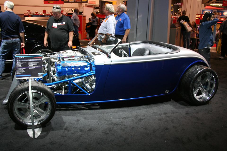 Blue and silver custom hot rod with exposed engine and chrome wheels