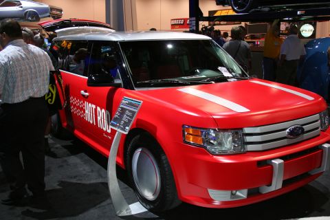 1998 Ford Crown Victoria - A customized red Ford Flex is displayed at a show, "Hot Rod" graphics and a two-tone silver and red exterior.