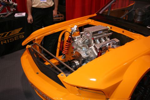 1998 Ford Crown Victoria - The engine bay of an orange custom car is displayed with a powerful V8 engine and racing suspension components.