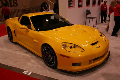 1998 Ford Crown Victoria - A bright yellow sports car is displayed indoors on a carpeted floor.