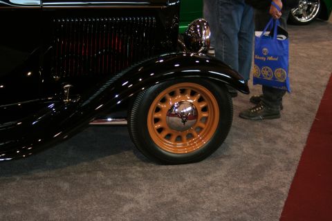 1998 Ford Crown Victoria - A close-up view of a classic black car with distinctive orange wheels and chrome details.