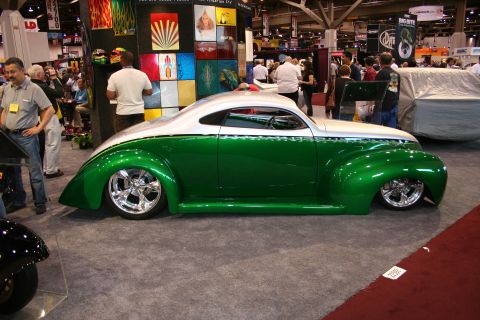 1998 Ford Crown Victoria - A custom two-tone green and white coupe with chrome wheels is displayed indoors.