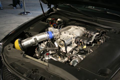 1998 Ford Crown Victoria - Close-up view of a modified engine bay a prominent supercharger and custom intake system.