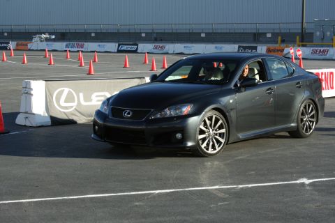 1998 Ford Crown Victoria - A driver is behind the wheel of a Lexus IS sedan during a track event with SEMA and Motor Trend branding visible.