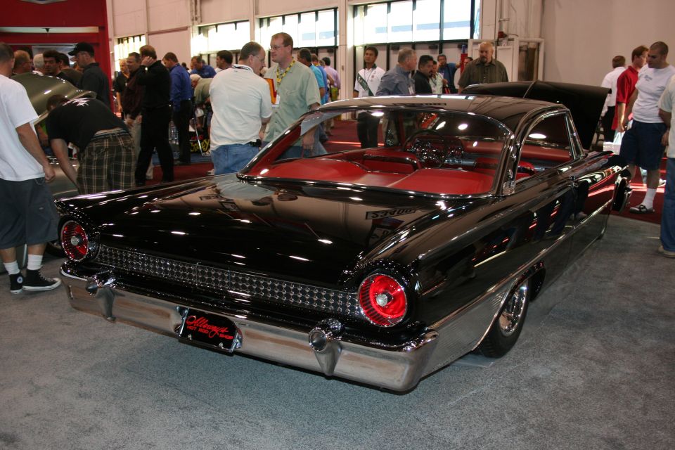 Black 1959 Ford Fairlane convertible rear view with red interior and chrome bumper