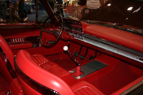 1998 Ford Crown Victoria - The vibrant red interior of a classic automobile features a detailed dashboard and plush seating.