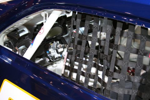 1998 Ford Crown Victoria - The interior of a race car is shown, a safety net and the steering column.