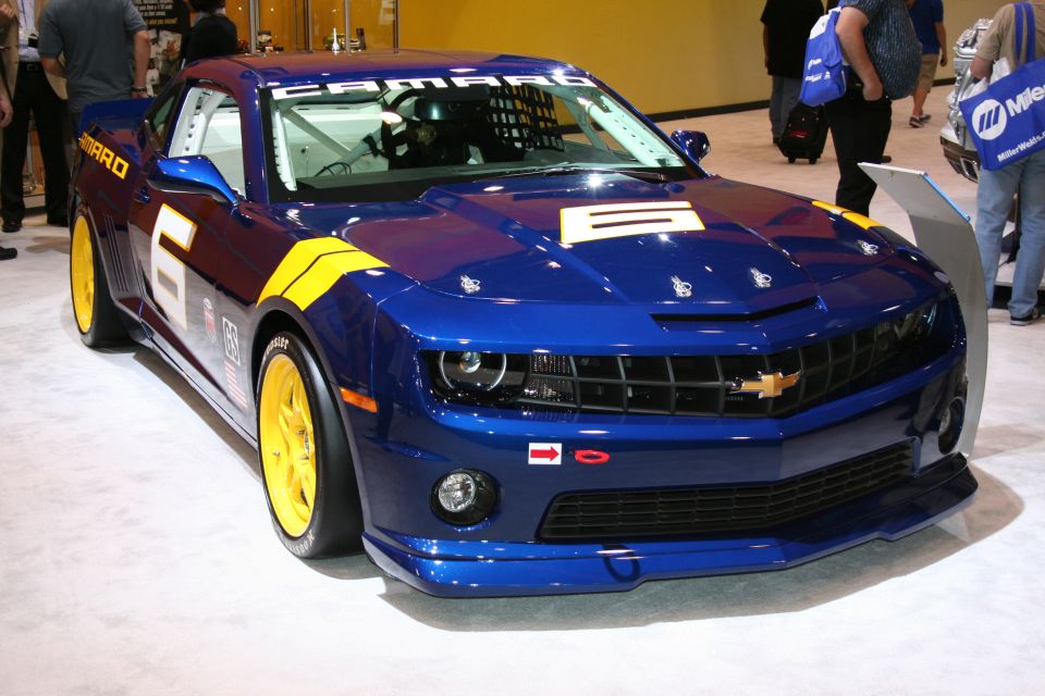 Blue race car with yellow stripes and the number 6 on the side. It has a roll cage visible inside
