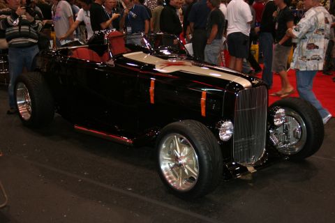 1998 Ford Crown Victoria - A custom hot rod with a prominent chrome grille and racing stripes is displayed indoors.