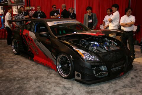 1998 Ford Crown Victoria - Customized black sports car with extensive graphics and an exposed engine compartment is displayed indoors.