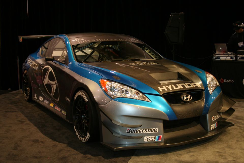 Hyundai Genesis race car with blue and silver paint, Bridgestone tires, and a large rear spoiler