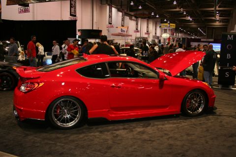 1998 Ford Crown Victoria - A red coupe is displayed with its hood open at an indoor event.